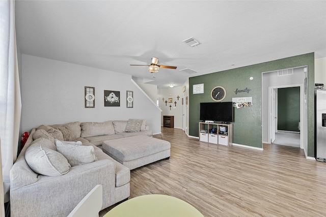 living room with ceiling fan and light hardwood / wood-style flooring