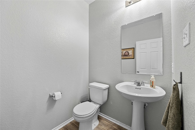 bathroom with toilet and wood-type flooring