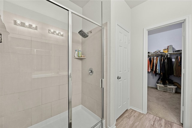 bathroom with a shower with door and hardwood / wood-style flooring