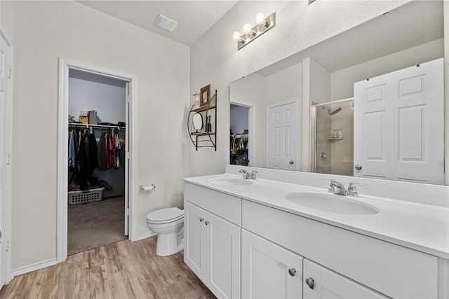 bathroom with wood-type flooring, an enclosed shower, vanity, and toilet