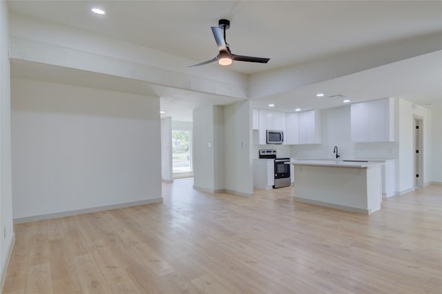 kitchen featuring ceiling fan, white cabinets, appliances with stainless steel finishes, and light wood-type flooring