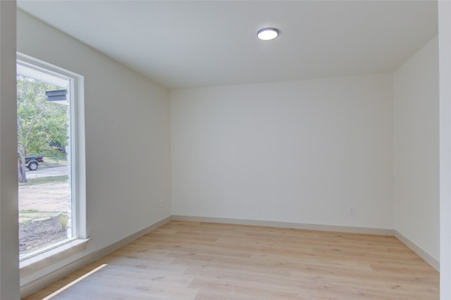 empty room with light hardwood / wood-style floors and a wealth of natural light