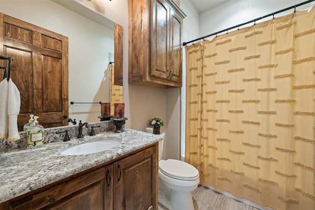 bathroom with vanity, toilet, and curtained shower