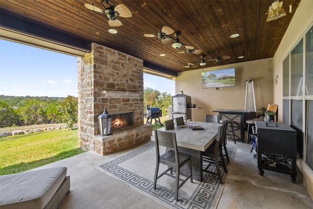 view of patio / terrace featuring ceiling fan and an outdoor stone fireplace