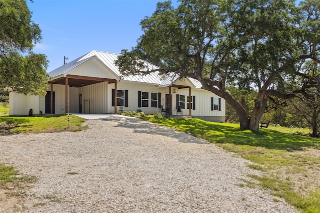 modern inspired farmhouse with a carport and a front yard