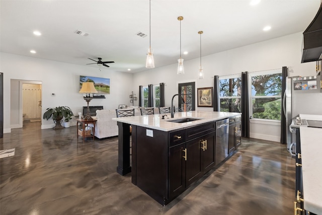 kitchen featuring appliances with stainless steel finishes, hanging light fixtures, ceiling fan, a kitchen island with sink, and sink