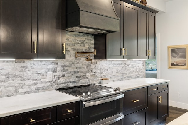 kitchen with decorative backsplash, stainless steel range with electric stovetop, dark wood-type flooring, and premium range hood