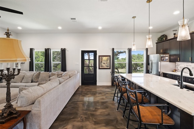 living room with ceiling fan and sink