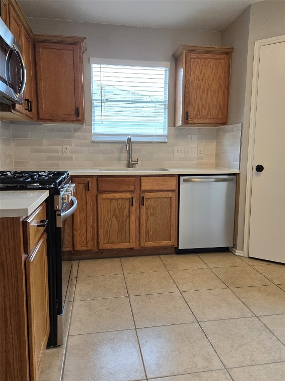 kitchen featuring light tile patterned floors, decorative backsplash, sink, and stainless steel appliances