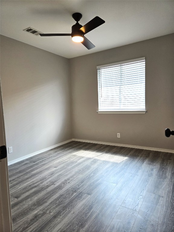 unfurnished room with ceiling fan and dark hardwood / wood-style flooring