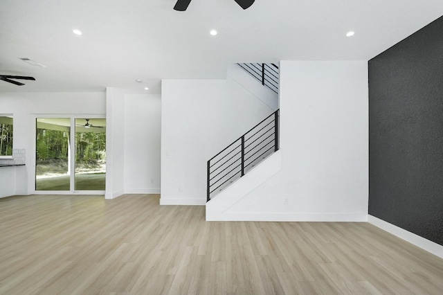 unfurnished living room with ceiling fan and light wood-type flooring