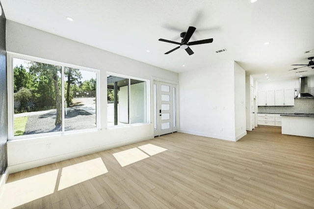 unfurnished living room featuring light wood-type flooring and ceiling fan