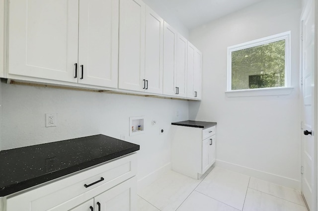 clothes washing area with light tile patterned floors, cabinets, and washer hookup