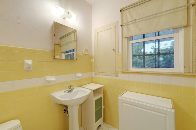 bathroom featuring tile walls and toilet