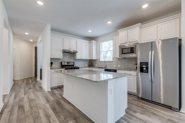 kitchen with stainless steel appliances, a center island, and white cabinetry