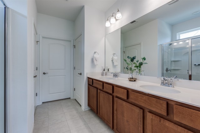 bathroom featuring vanity, a shower with door, and tile patterned floors