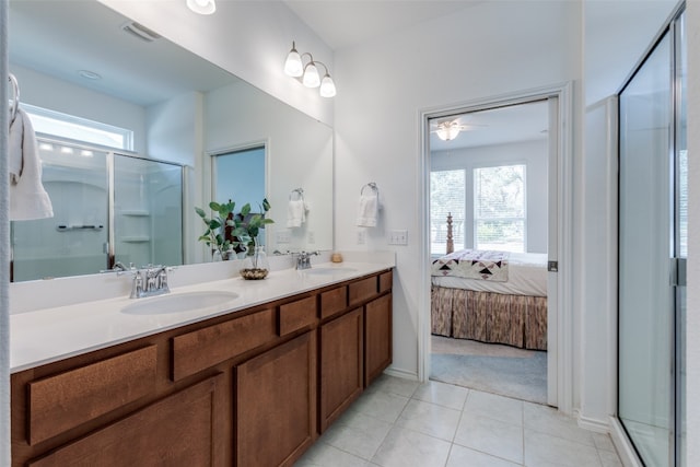 bathroom featuring a shower with shower door, vanity, ceiling fan, and plenty of natural light