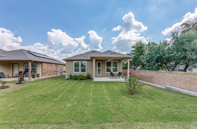 rear view of property featuring a patio area and a yard