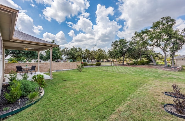 view of yard with ceiling fan and a patio area