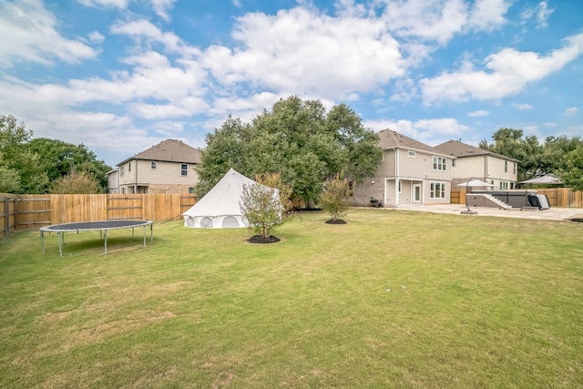 view of yard featuring a trampoline and a patio