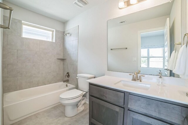 full bathroom featuring tiled shower / bath combo, tile patterned flooring, vanity, and toilet