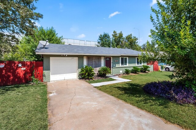 ranch-style home with a garage and a front lawn