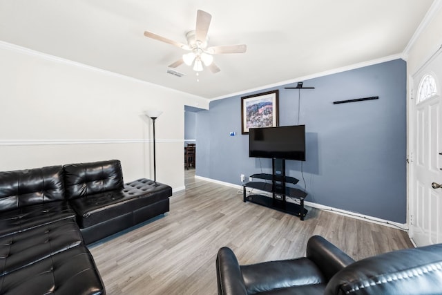 living room with light hardwood / wood-style flooring, ornamental molding, and ceiling fan