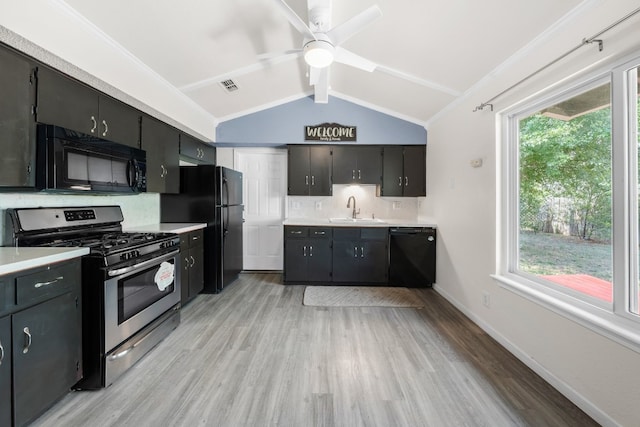 kitchen featuring sink, tasteful backsplash, lofted ceiling with beams, black appliances, and light wood-type flooring