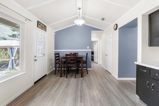 dining room featuring lofted ceiling, crown molding, and light hardwood / wood-style floors