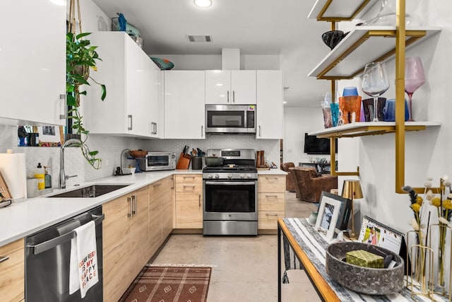 1001 Juanita St, Austin, TX 78704 - kitchen with appliances with stainless steel finishes, tasteful backsplash, finished concrete floors, light countertops, and white cabinets