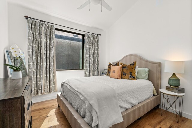 bedroom featuring lofted ceiling, ceiling fan, baseboards, and wood finished floors