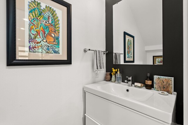 bathroom with vanity and lofted ceiling