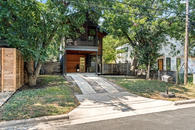 view of front of property featuring stairs, driveway, and fence