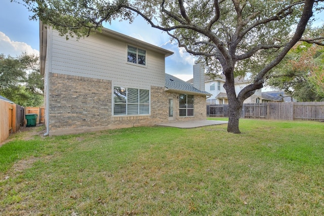 rear view of house featuring a patio area and a yard