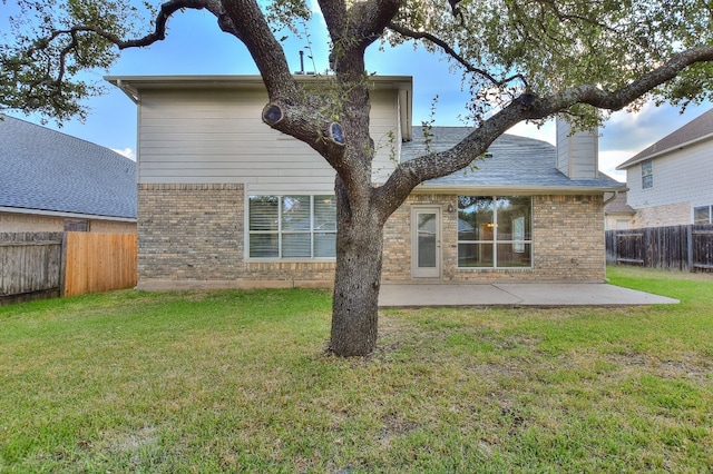 back of house featuring a lawn and a patio area