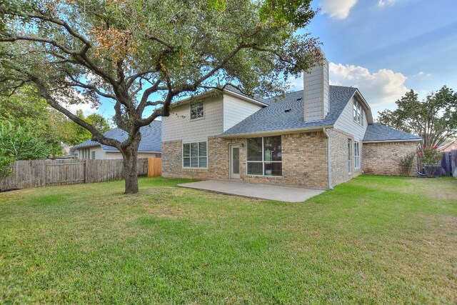 rear view of house with a lawn and a patio