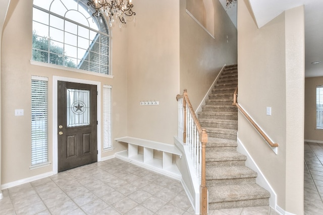 entryway featuring a high ceiling, an inviting chandelier, and plenty of natural light