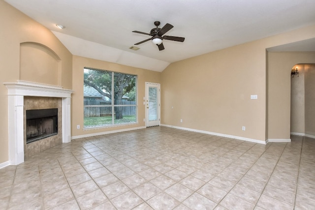 unfurnished living room featuring lofted ceiling, light tile patterned flooring, a tiled fireplace, and ceiling fan