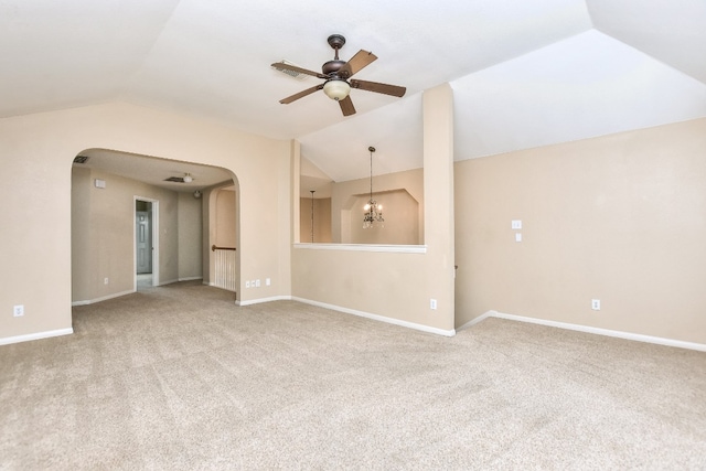 unfurnished living room with carpet flooring, ceiling fan with notable chandelier, and vaulted ceiling