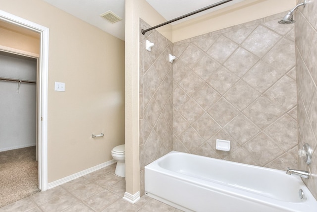 bathroom featuring tiled shower / bath, toilet, and tile patterned floors