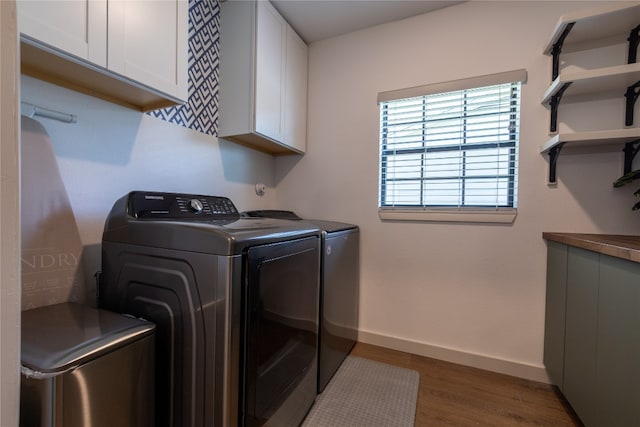 clothes washing area with cabinets, dark hardwood / wood-style floors, and independent washer and dryer