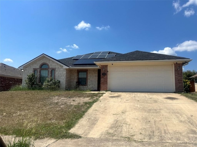 2207 Gail Dr, Copperas Cove, TX 76522 - ranch-style home featuring solar panels, concrete driveway, an attached garage, brick siding, and a shingled roof