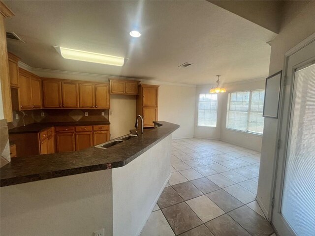 2207 Gail Dr, Copperas Cove, TX 76522 - kitchen featuring a sink, dark countertops, ornamental molding, light tile patterned floors, and a chandelier