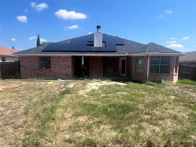 2207 Gail Dr, Copperas Cove, TX 76522 - back of property featuring brick siding, solar panels, and a chimney