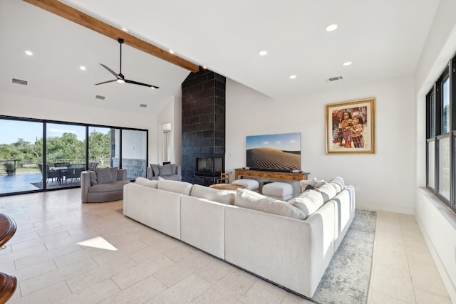 living room with ceiling fan, beam ceiling, high vaulted ceiling, and a tile fireplace