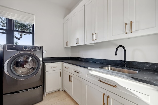 laundry room featuring light tile patterned floors, washer / clothes dryer, cabinets, and sink