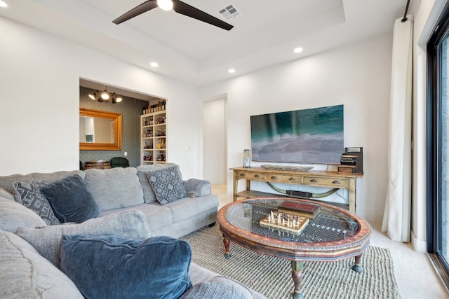 living room with ceiling fan with notable chandelier and a fireplace