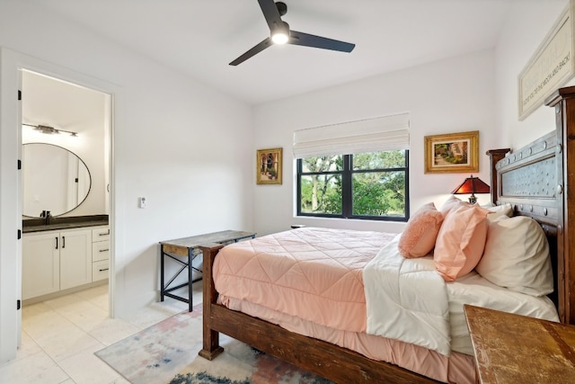 tiled bedroom featuring ceiling fan, ensuite bathroom, and sink