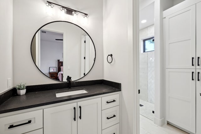 bathroom featuring a tile shower and vanity