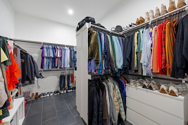 spacious closet featuring dark tile patterned flooring